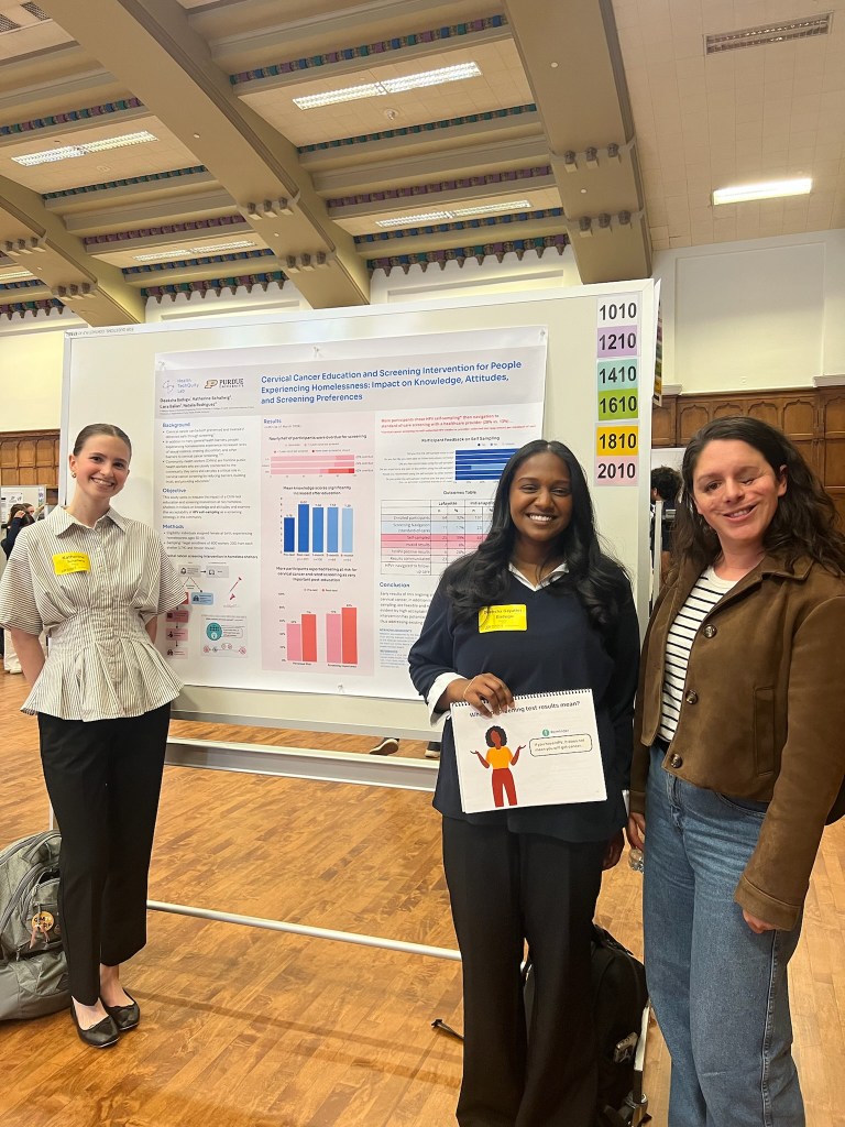 Katherine and Deeksha presenting a poster at the Spring Undergraduate Research Conference at Purdue, standing with Natalia Rodriguez